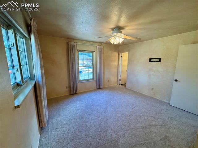 280 Raven Hills Road Colorado Springs, CO 80919 - Photo 19 of 48 Carpeted empty room featuring a textured ceiling and ceiling fan