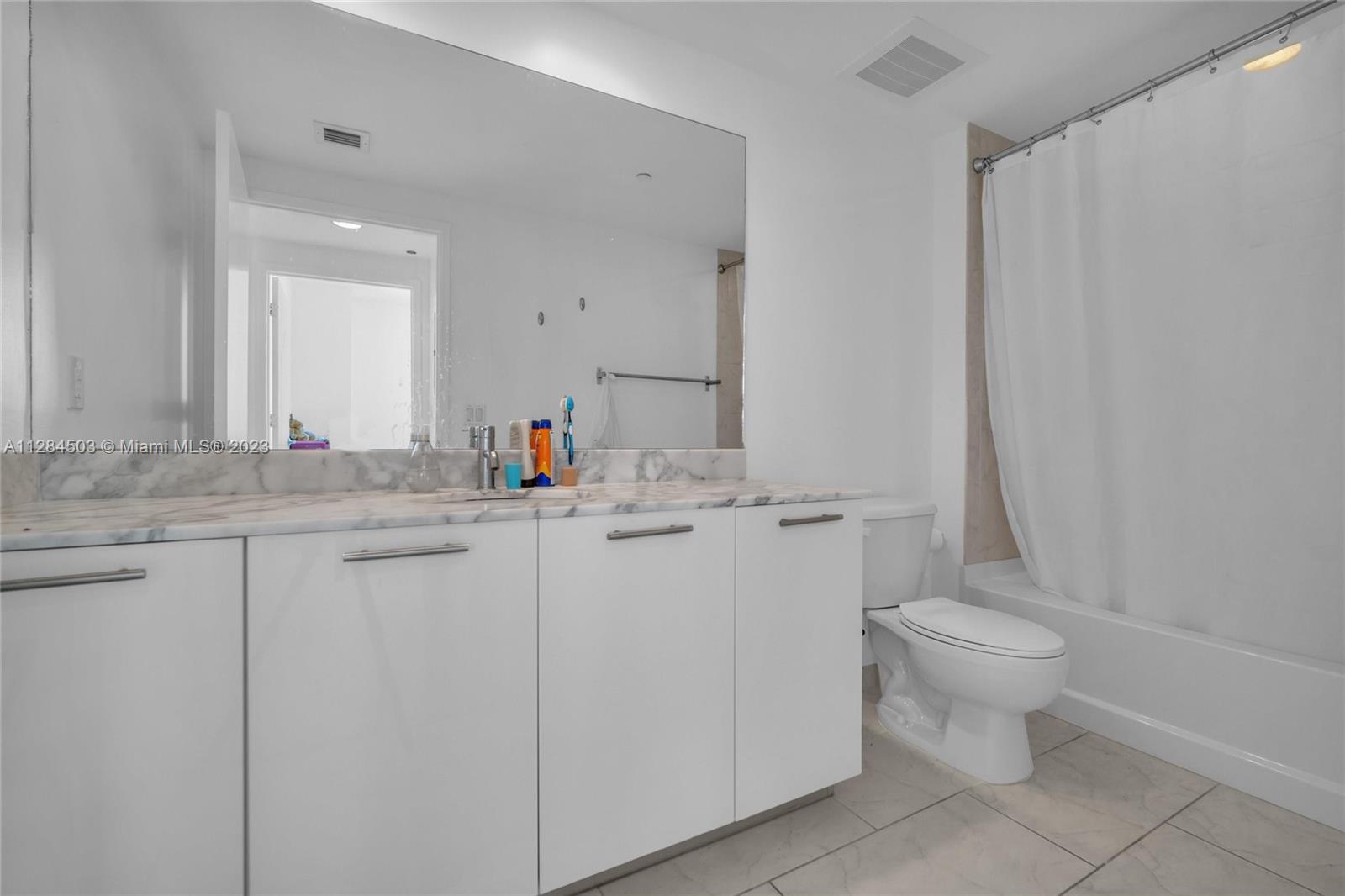 Brickell Miami, FL 33131 - Photo 13 of 29 a bathroom with a sink toilet and a mirror