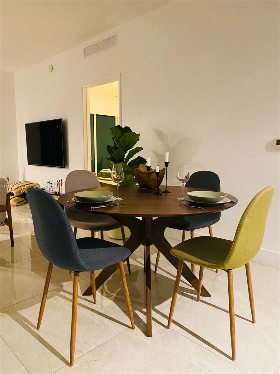 Brickell Miami, FL 33131 - Photo 10 of 29 a view of a dining room with furniture and a flat screen tv