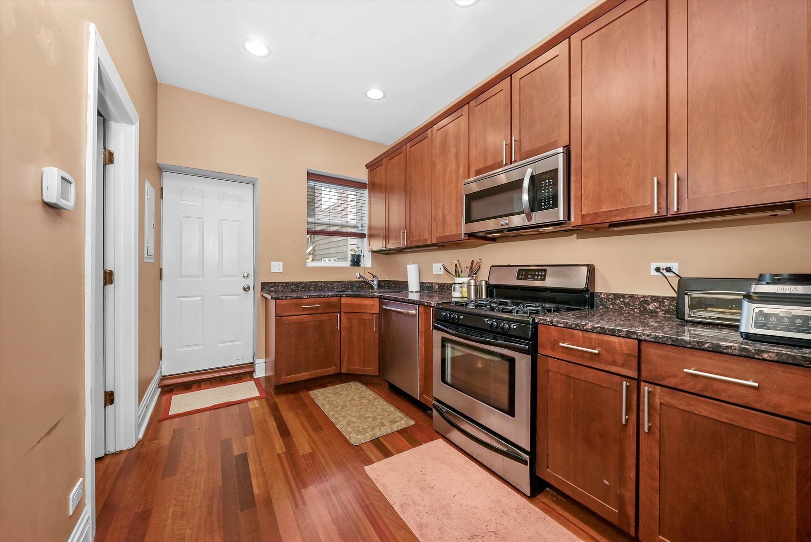 5342 North Winthrop Avenue, Unit 2E Chicago, IL 60640 - Photo 6 of 8 a kitchen with stainless steel appliances granite countertop a stove a sink and a microwave