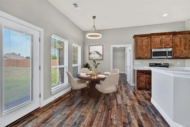 a dining room with wooden floor a glass table and chairs