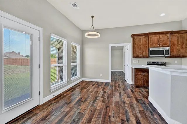 a view of kitchen with stainless steel appliances granite countertop a stove top oven