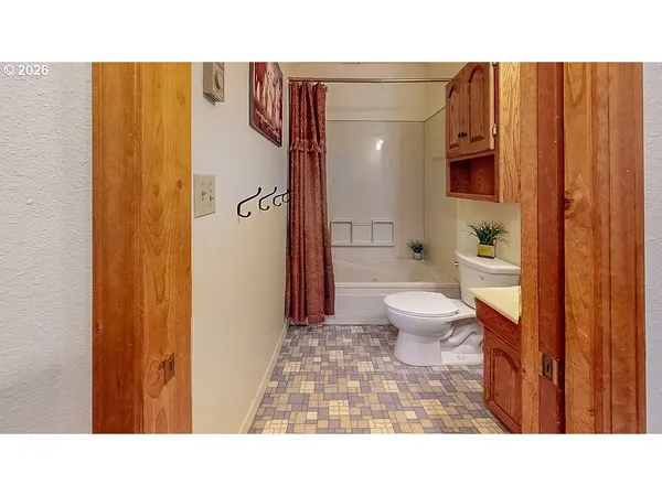 a bathroom with a toilet and a shower curtain