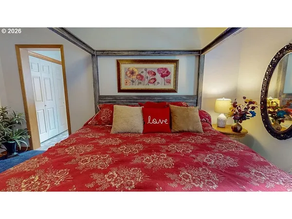 a bedroom with a bed and a painting on the wall