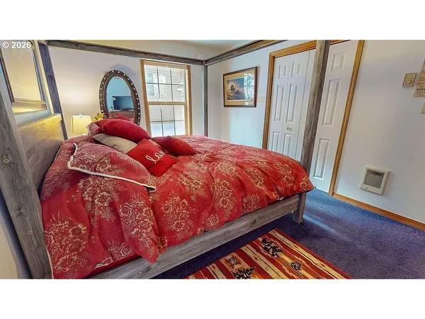 a bedroom with a bed and a large window