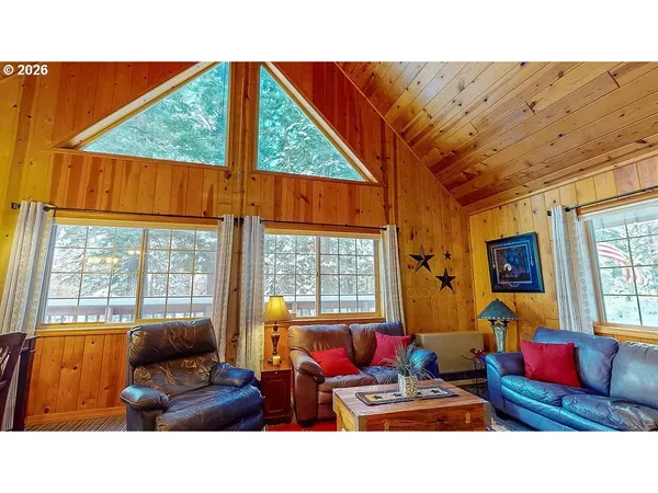 a living room with furniture a flat screen tv and a floor to ceiling window