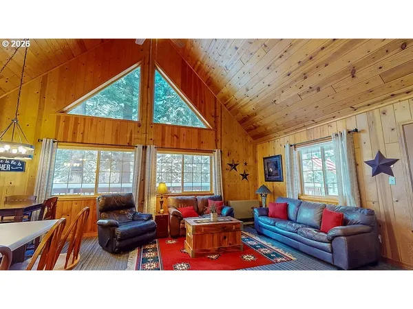 a living room with furniture a flat screen tv and a floor to ceiling window