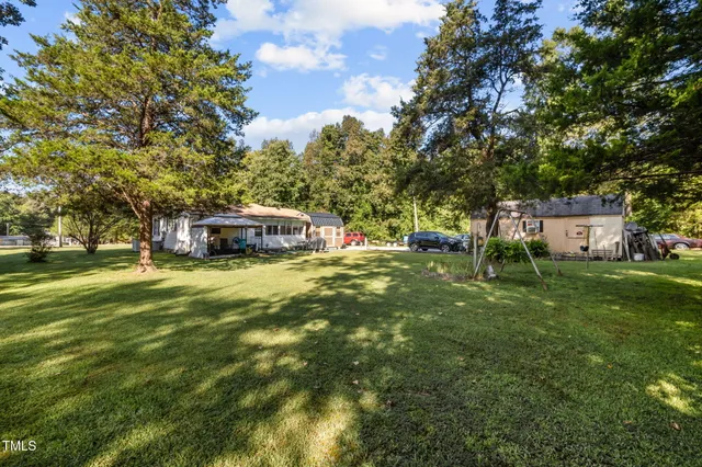 a view of a house with a yard patio and a tree