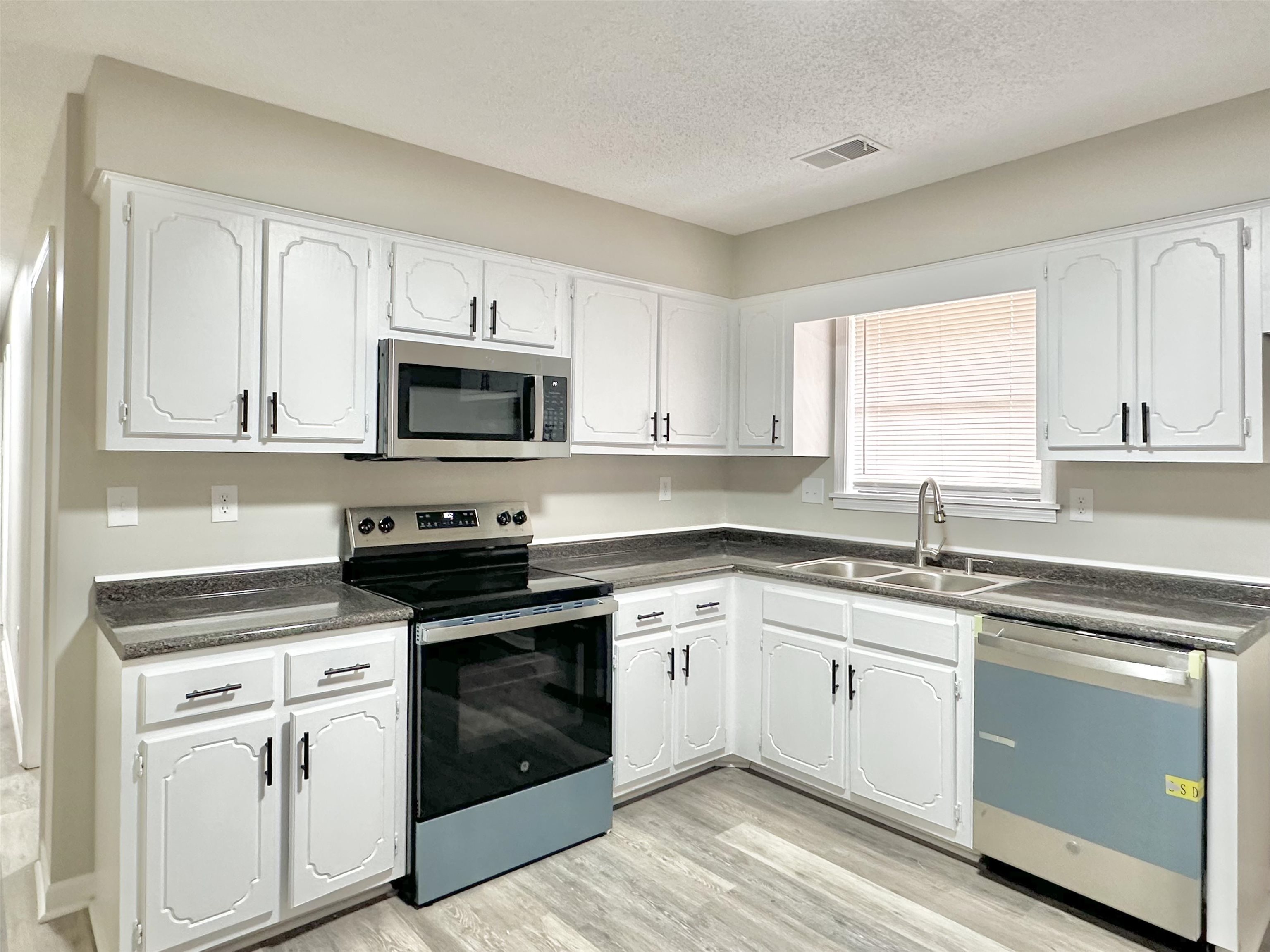 4376 Coleman Road Memphis, TN 38128 - Photo 5 of 21 a white kitchen with granite countertop white cabinets and a stove