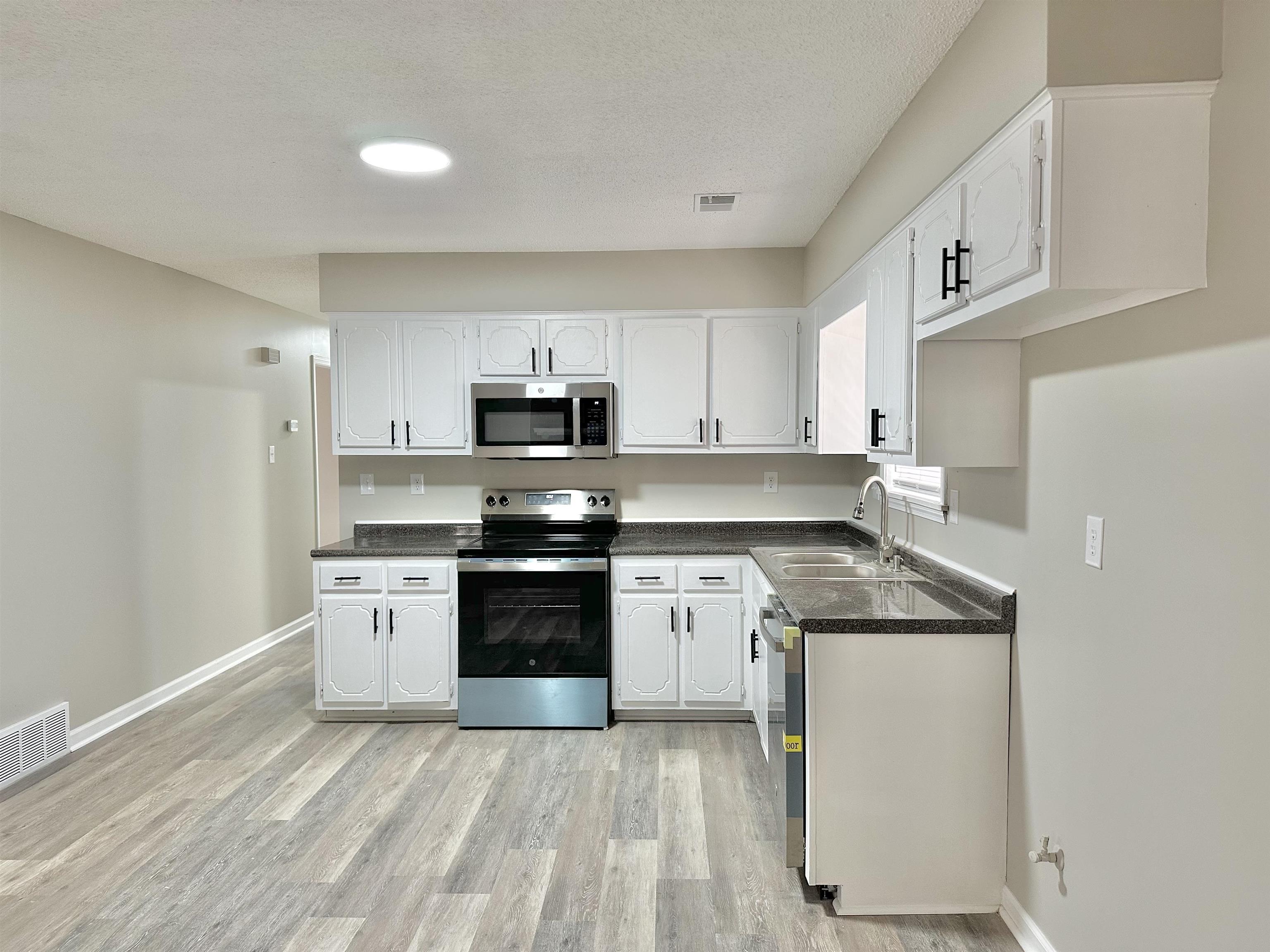 4376 Coleman Road Memphis, TN 38128 - Photo 6 of 21 a kitchen with stainless steel appliances granite countertop a stove a sink and white cabinets
