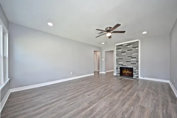 a view of empty room with wooden floor and fireplace