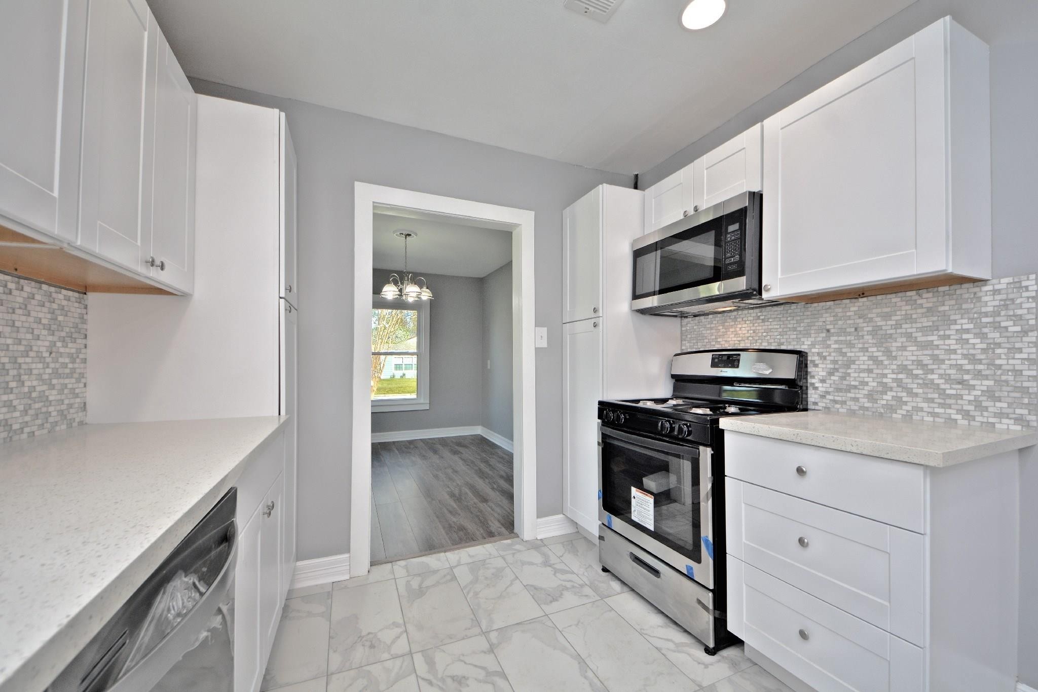 3834 Rosedale Street Houston, TX 77004 - Photo 25 of 48 a kitchen with stainless steel appliances granite countertop a stove and a microwave