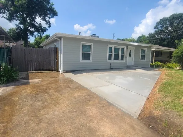 a view of a house with a yard and potted plants