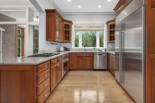 a large kitchen with stainless steel appliances granite countertop a sink dishwasher stove and cabinets