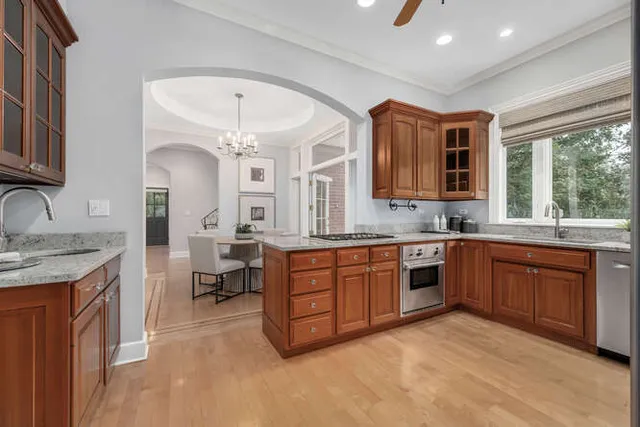 a kitchen with granite countertop a sink stove and cabinets