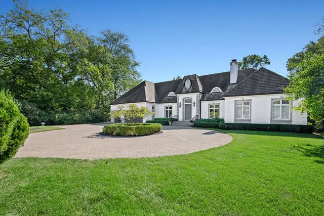 a front view of a house with a yard and trees