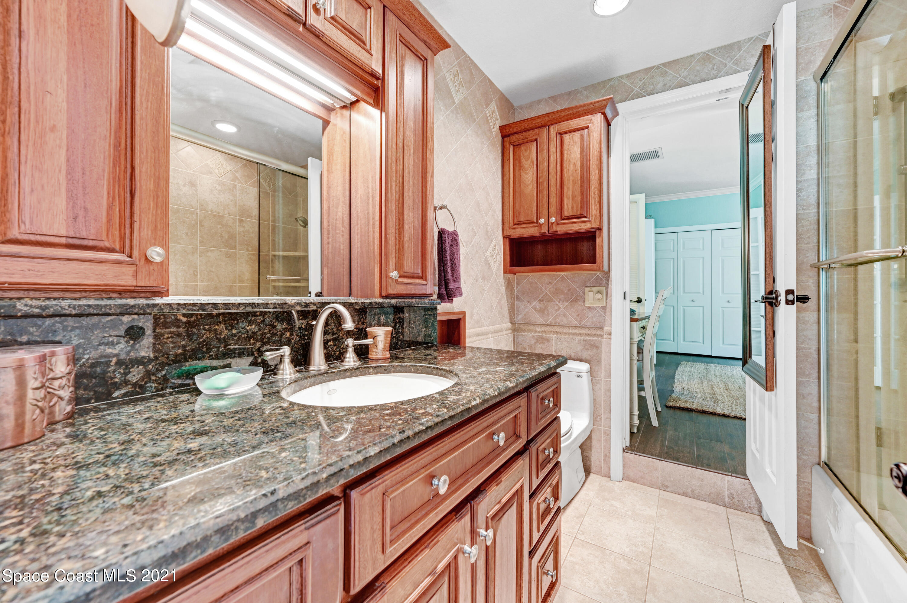 600 North Riverside Drive Indialantic, FL 32903 - Photo 70 of 85 a bathroom with a granite countertop sink and a mirror