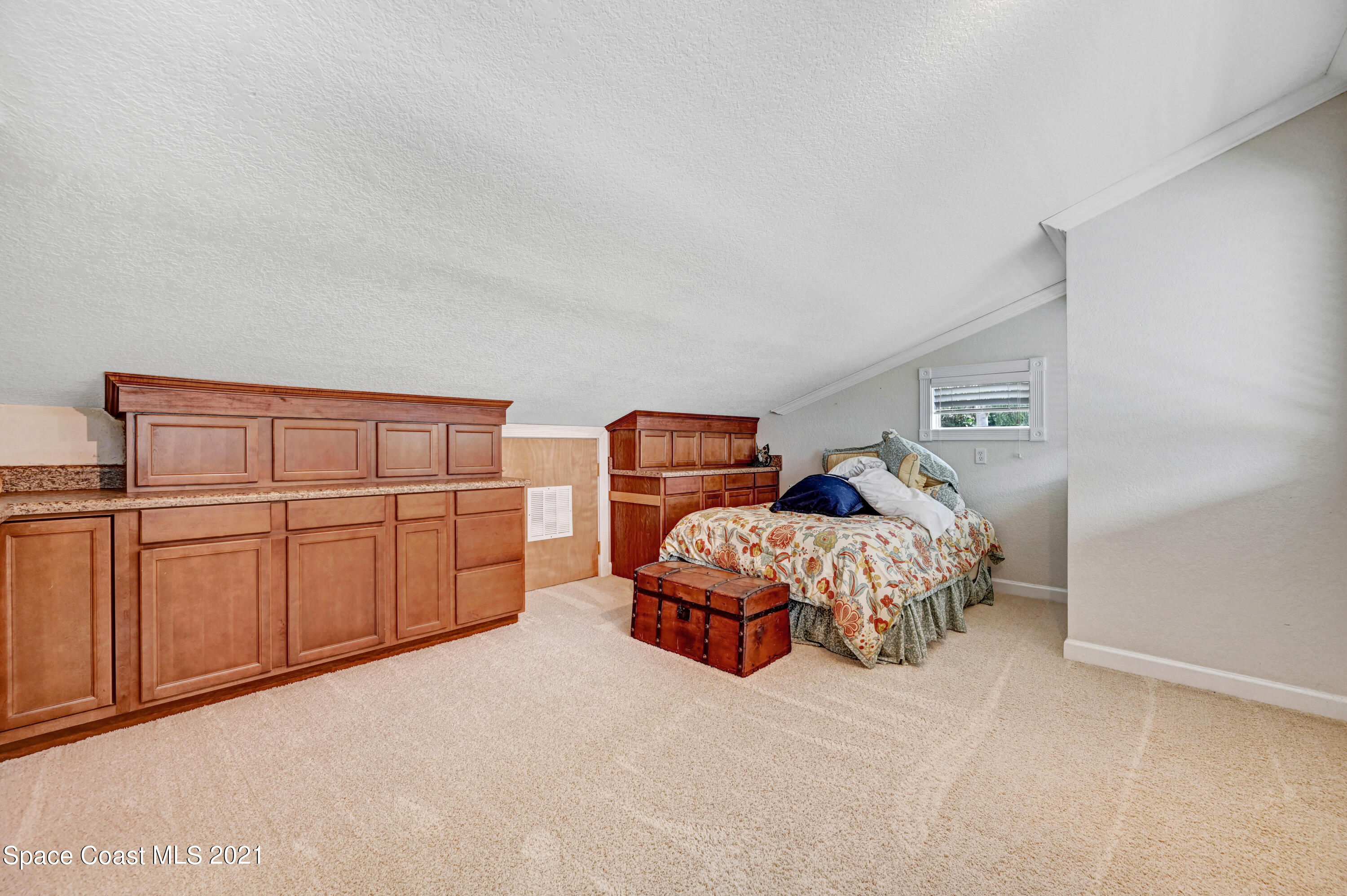 600 North Riverside Drive Indialantic, FL 32903 - Photo 74 of 85 a bedroom with a bed and cabinet