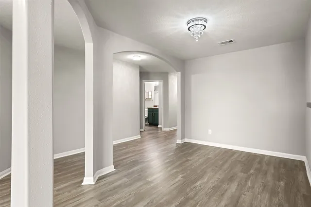 a view of an empty room with wooden floor