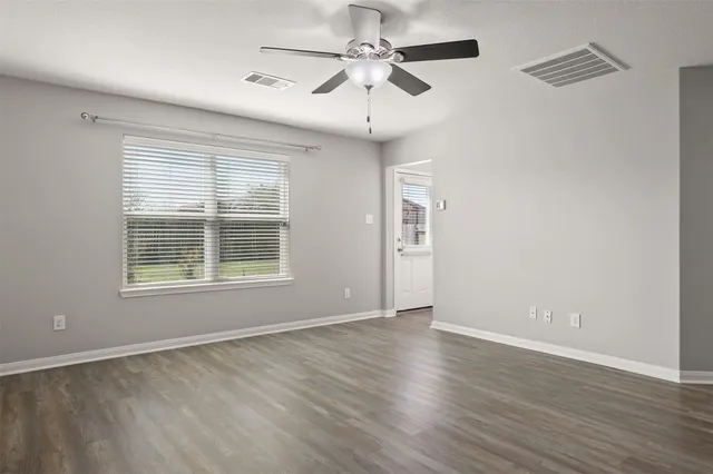 wooden floor in an empty room with a window