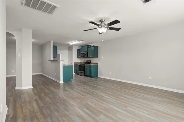 a view of a kitchen with wooden floor a sink and dishwasher