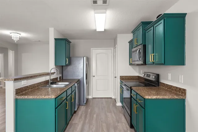 a kitchen with a sink stove and cabinets