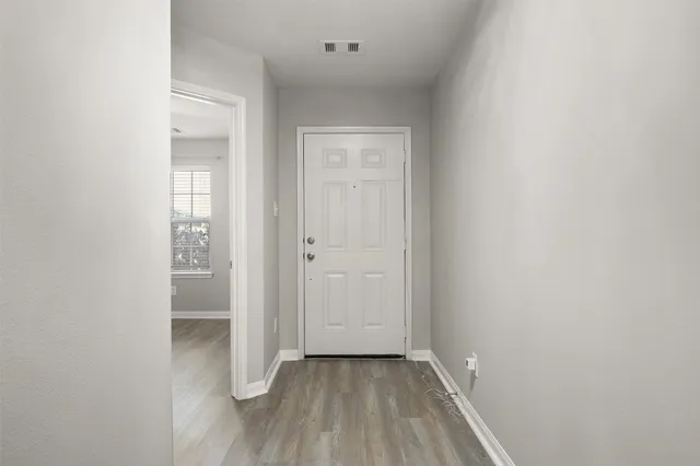 a view of a hallway with wooden floor