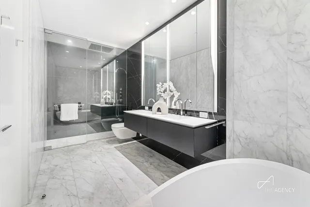 a bathroom with a double vanity sink mirror and a bathtub