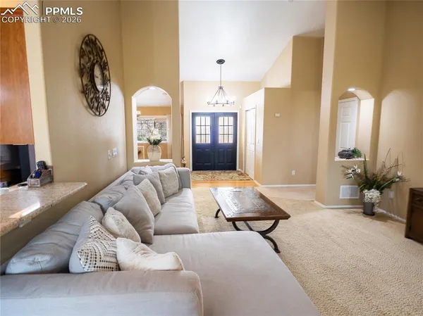 a living room with furniture flowerpot and a chandelier