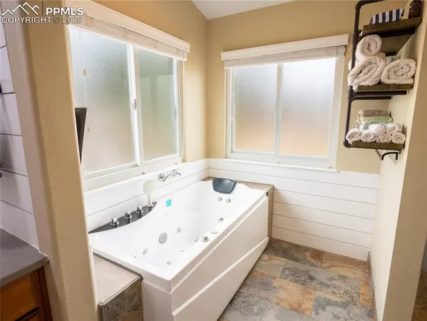 a bathroom with a tub sink and mirror