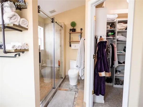 a view of a walk in closet and bathroom