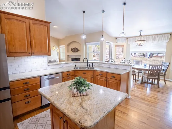 a kitchen with granite countertop a sink a counter top space and living room view