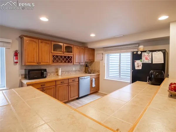 a large kitchen with stainless steel appliances kitchen island granite countertop a sink and cabinets