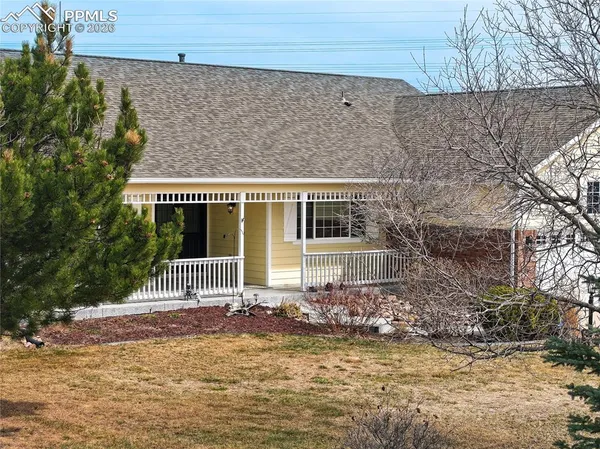 a front view of a house with a tree