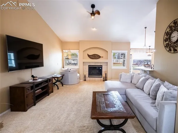 a living room with furniture a flat screen tv and a fireplace