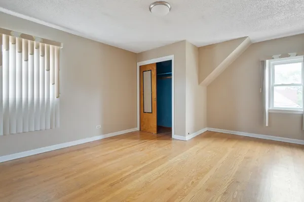 an empty room with window and closet area