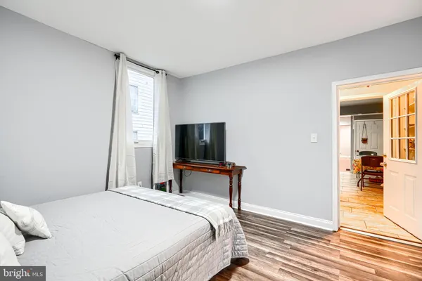 a view of an empty room with wooden floor and window