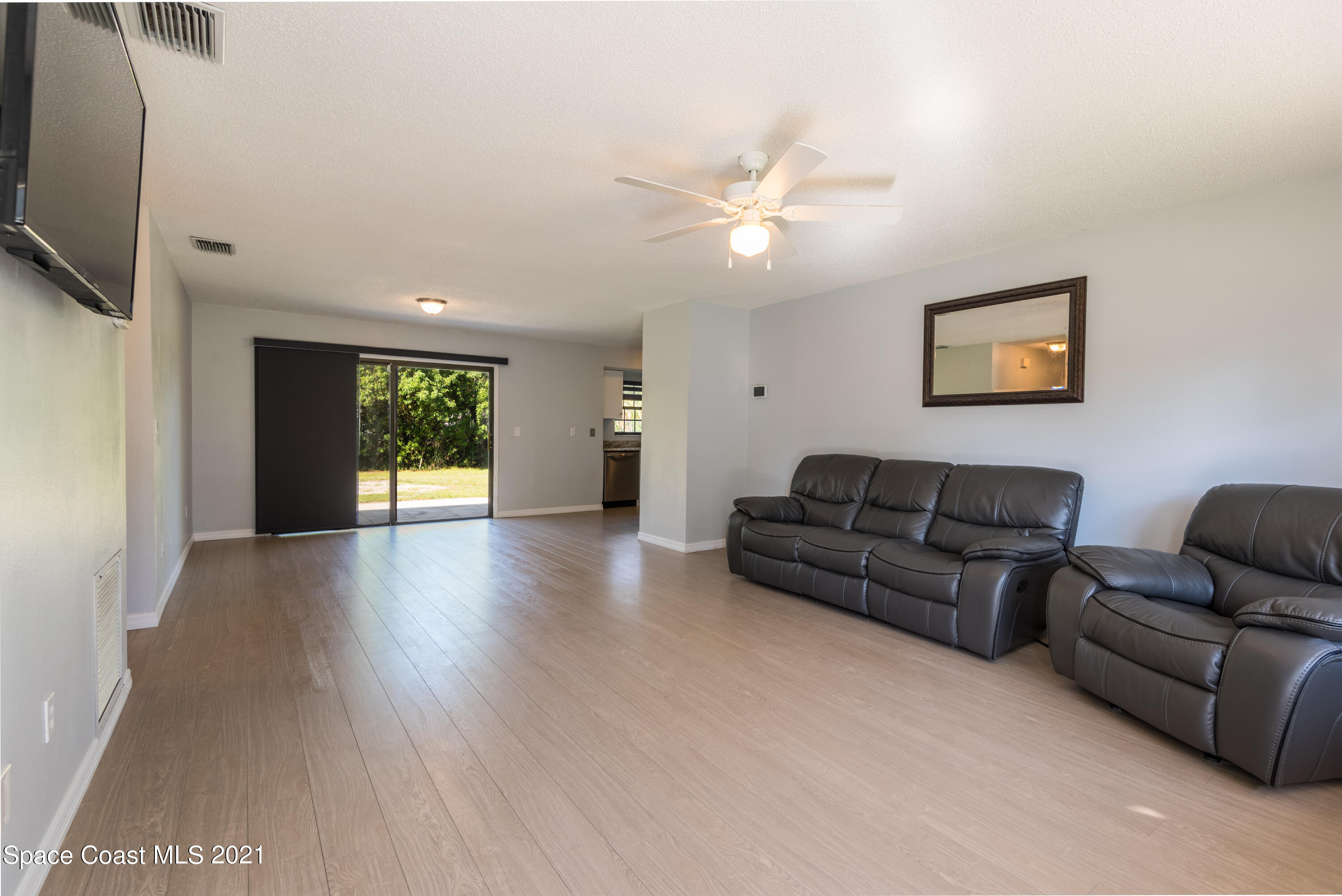 1077 San Rafael Road Southwest Palm Bay, FL 32908 - Photo 2 of 13 a living room with furniture and a flat screen tv