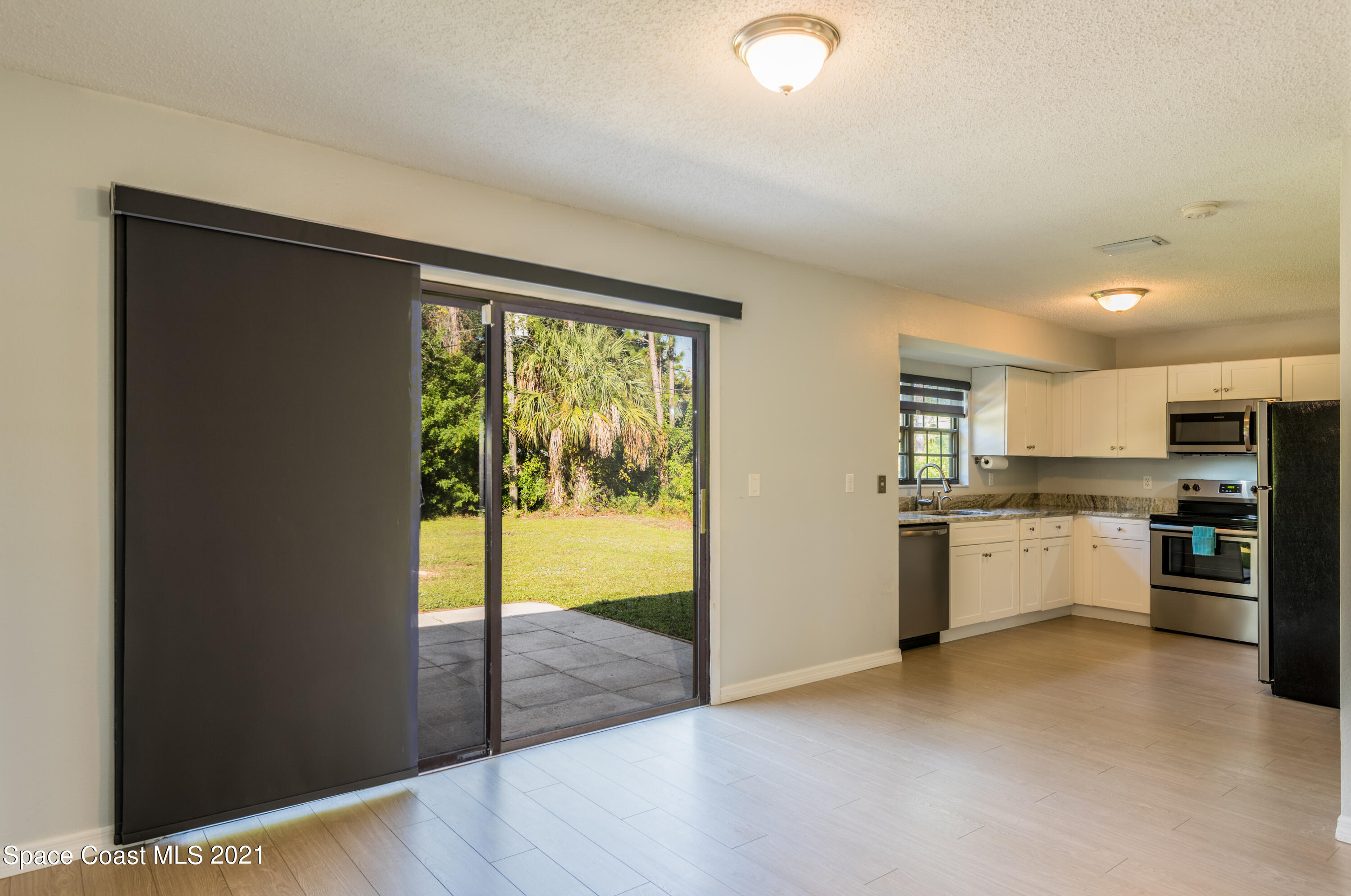 1077 San Rafael Road Southwest Palm Bay, FL 32908 - Photo 3 of 13 a large white kitchen with a refrigerator a stove a microwave and a sink