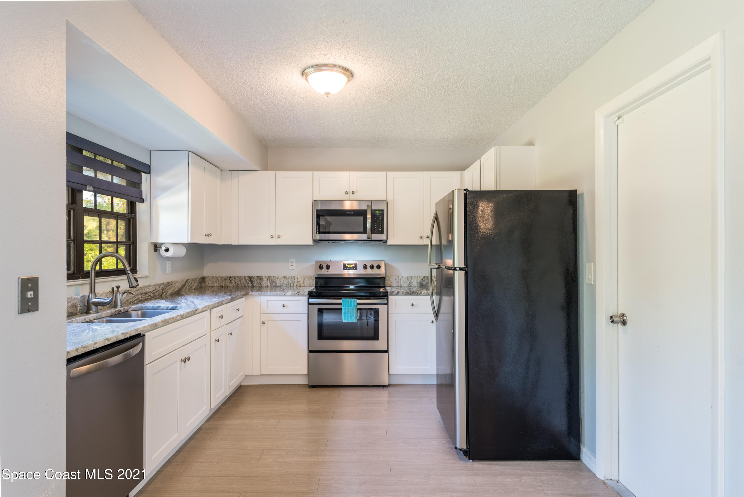 1077 San Rafael Road Southwest Palm Bay, FL 32908 - Photo 4 of 13 a kitchen with stainless steel appliances granite countertop a refrigerator and a stove top oven