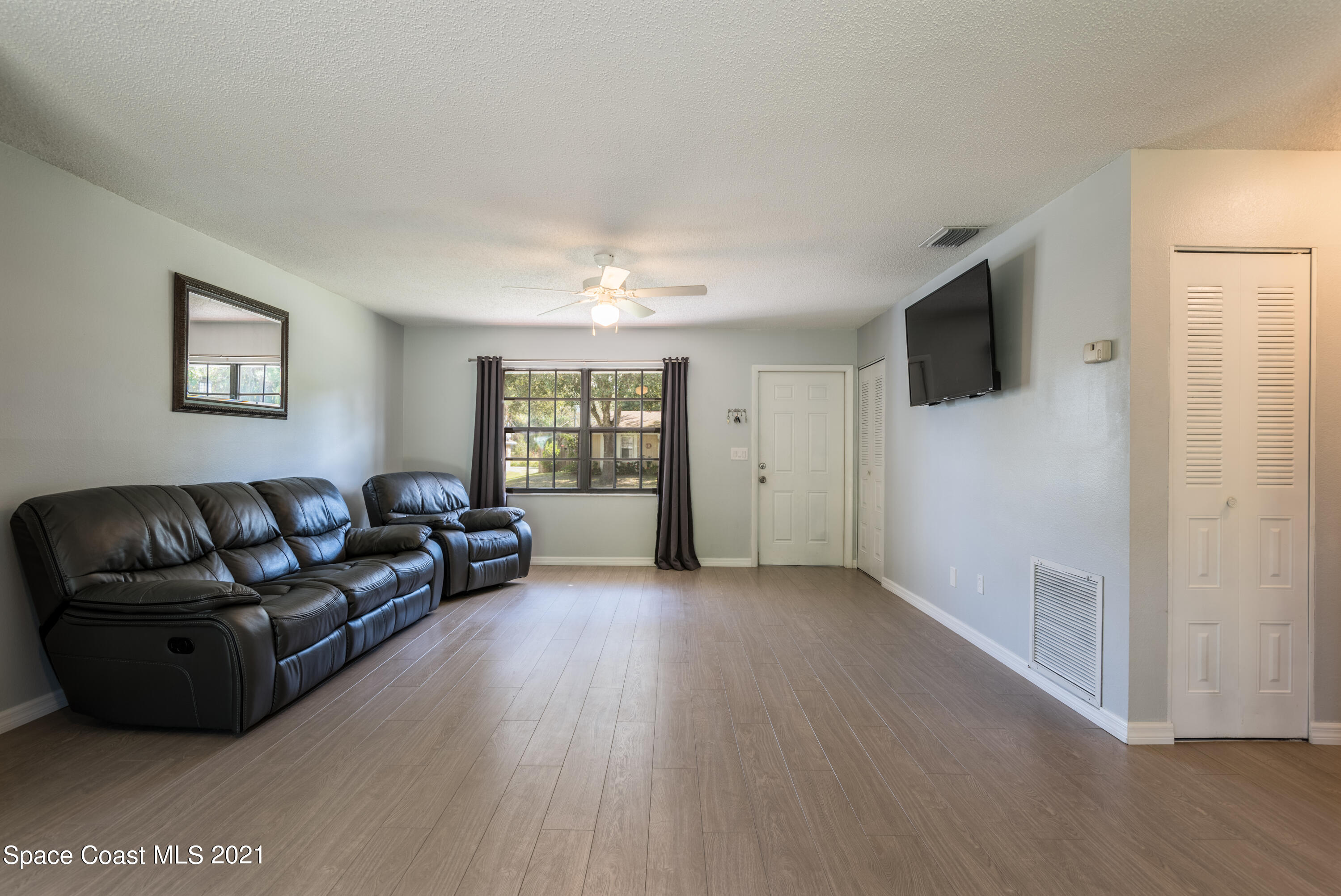 1077 San Rafael Road Southwest Palm Bay, FL 32908 - Photo 5 of 13 a living room with furniture and a flat screen tv