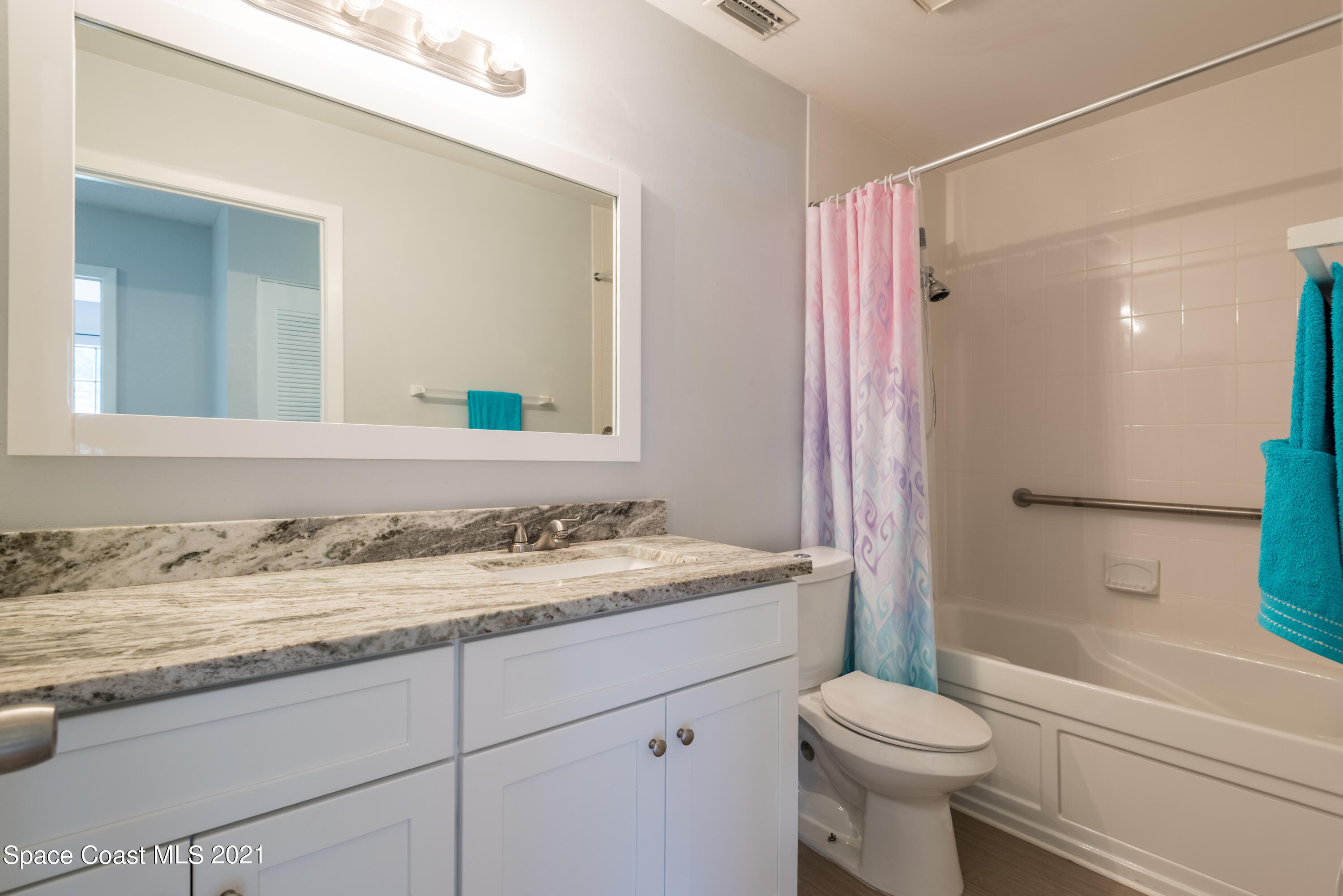1077 San Rafael Road Southwest Palm Bay, FL 32908 - Photo 10 of 13 a bathroom with a granite countertop sink toilet mirror and shower