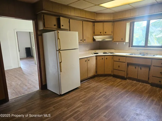 a kitchen with a refrigerator sink and cabinets