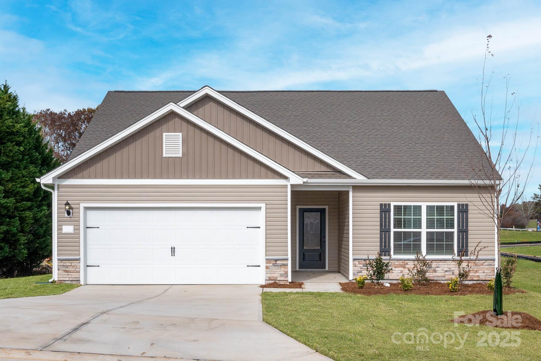 a front view of a house with a yard garage and outdoor seating