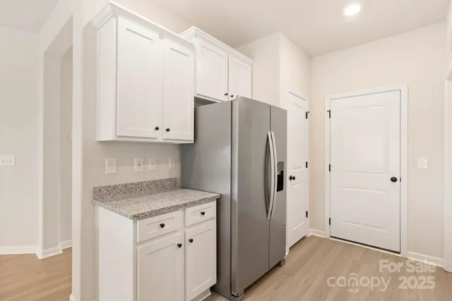 a kitchen with granite countertop cabinets and refrigerator
