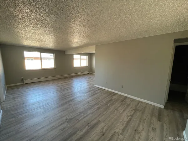 a view of empty room with wooden floor