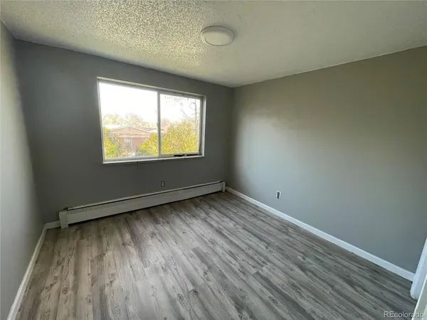 a view of an empty room with wooden floor
