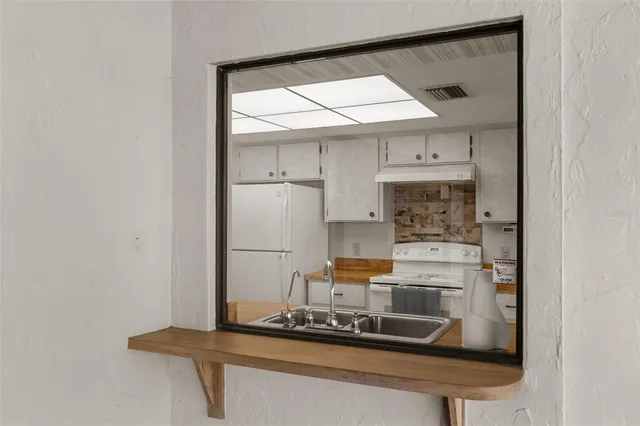 a kitchen with a refrigerator and white cabinets