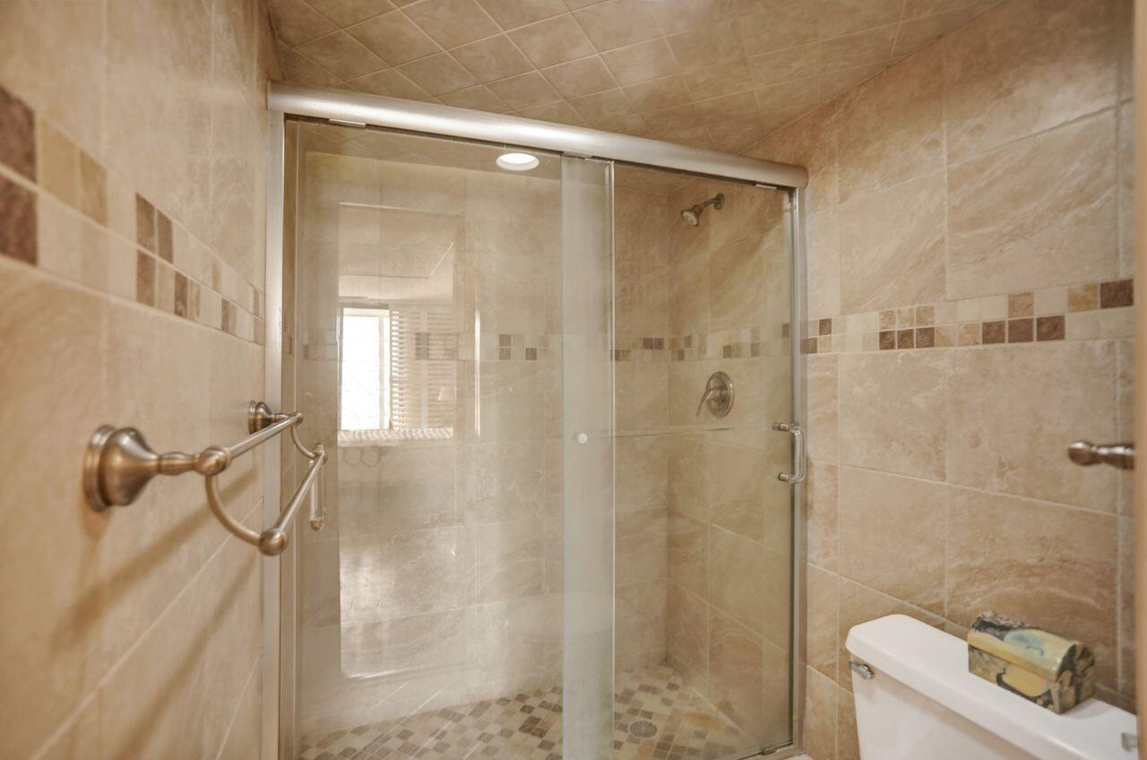100 Ocean Trail Way, Unit 109 Jupiter, FL 33477 - Photo 8 of 27 a bathroom with a shower and a toilet