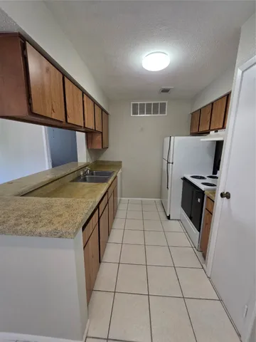 a kitchen with a sink a stove cabinets and a counter top space